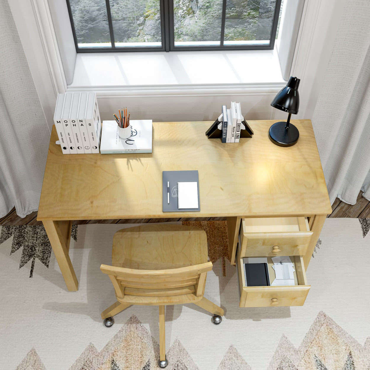 Modern minimalist home office desk with books, lamp, and chair by a window.