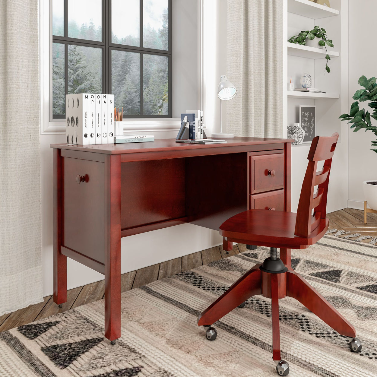 Red wooden desk and chair set in a modern home office with books, lamp, and large window background.