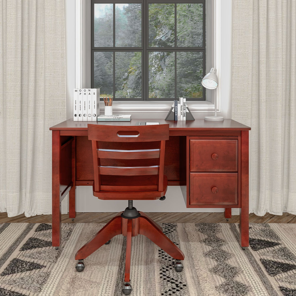 Wooden home office desk with drawers, swivel chair, and laptop near a window.