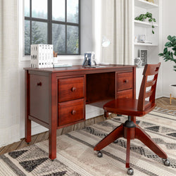 Wooden office desk and chair in cozy home office setup with books, lamp, and window view.