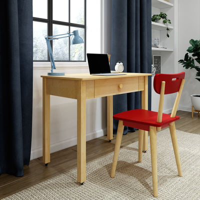 Minimal home office study nook with small light wood desk with drawer, red wooden chair, blue adjustable desk lamp, laptop, white alarm clock, navy curtains, window and potted plant