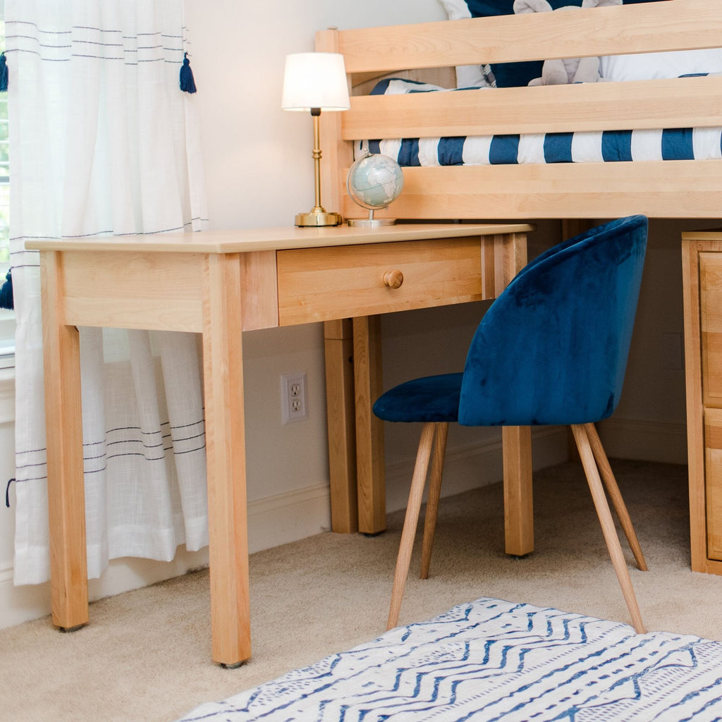 Modern kids bedroom study nook with light wood desk and drawer, blue velvet chair, brass lamp and globe under a wooden bunk bed with blue striped bedding