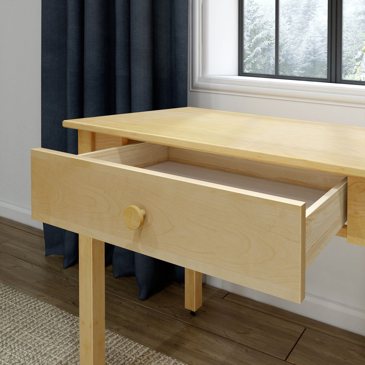 Light wood desk with open drawer in modern home office by window, hardwood floor and dark curtains