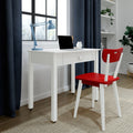 White wooden desk with drawer, red wooden chair, blue adjustable desk lamp and laptop by window with navy curtains in a modern minimalist small home office workspace