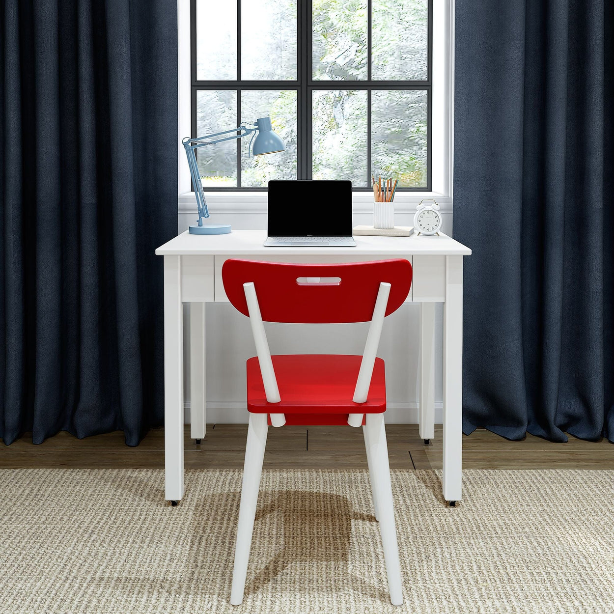 Modern minimalist home office workspace with white desk and red chair, laptop, blue desk lamp, pencil holder, alarm clock and window with dark curtains
