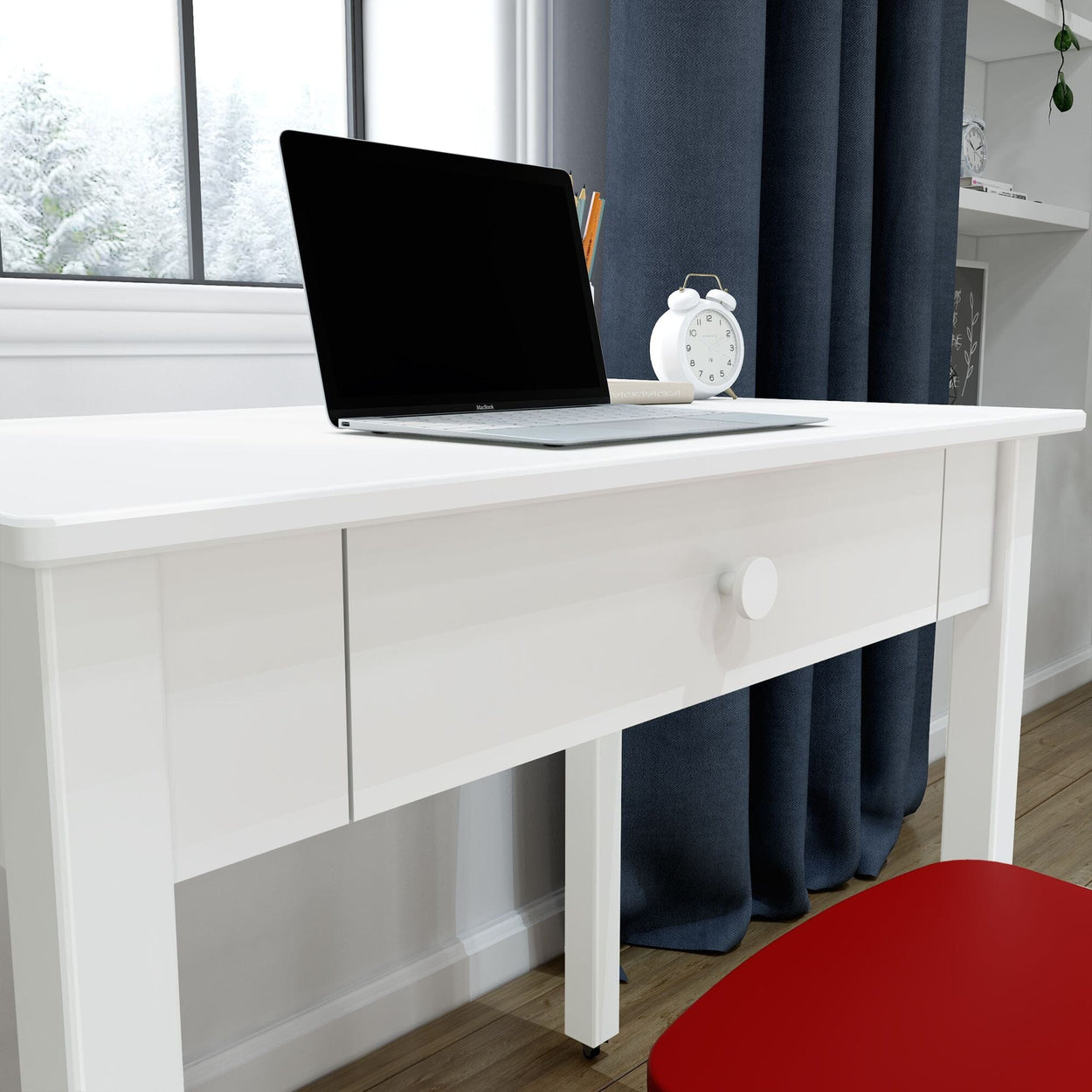 White modern desk with laptop and alarm clock beside snowy window and navy curtains, red chair in home office workspace