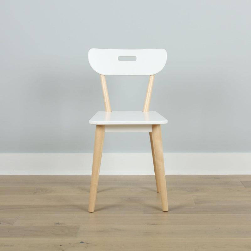 Minimalist white Scandinavian dining chair with light wood legs against a pale gray wall on a hardwood floor