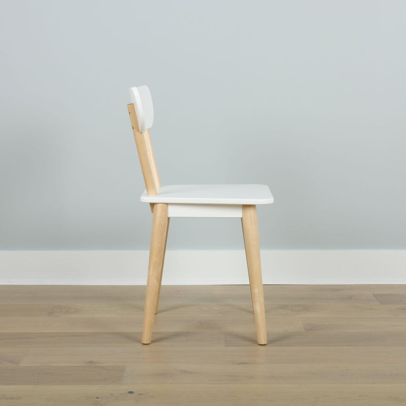 Minimalist Scandinavian wooden dining chair with white seat and backrest, natural wood legs on light hardwood floor against pale gray wall