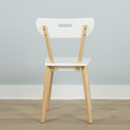 Modern white dining chair with light wooden legs in Scandinavian minimalist design, back view on hardwood floor against pale gray wall