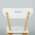 White modern Scandinavian dining chair with light wood legs and cutout handle on backrest, minimalist seating