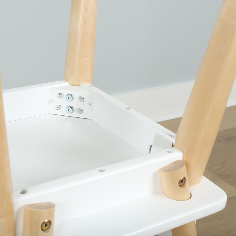 Close-up of white plastic baby high chair underside with natural wood legs, metal screws and bracket mounting hardware