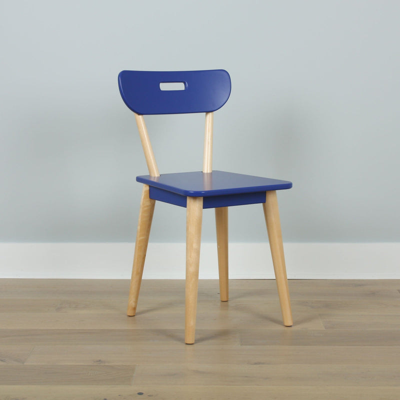 Blue modern dining chair with natural wood legs on light hardwood floor against pale gray wall, minimalist Scandinavian interior decor