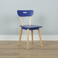 Modern blue wooden chair with light oak legs in a minimalist interior on hardwood floor