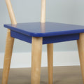Close-up of blue wooden chair seat with light natural wood legs, modern Scandinavian minimalist furniture