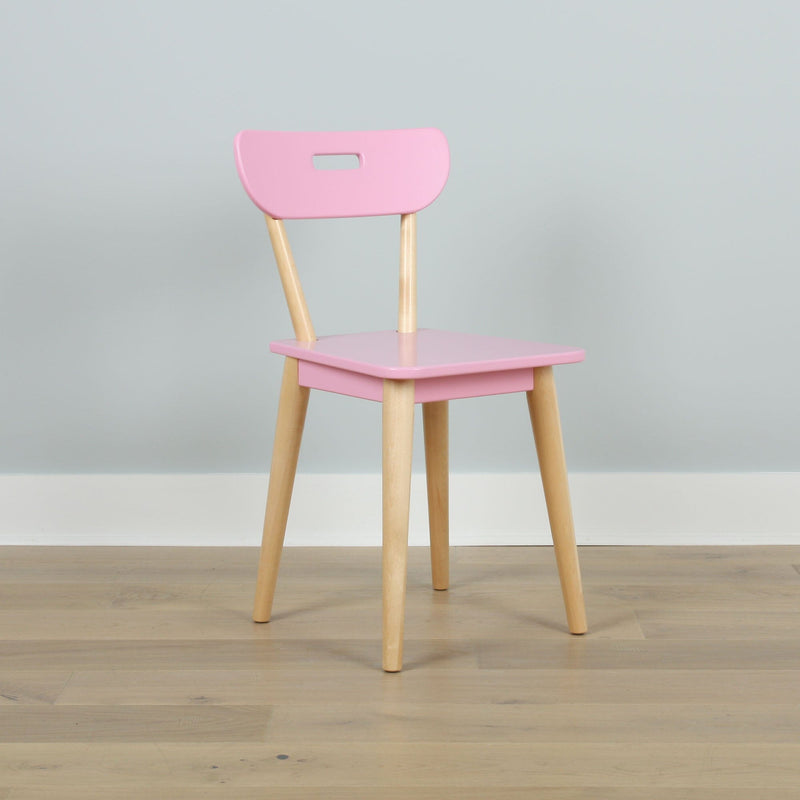 Pink children's chair with natural wooden legs on hardwood floor against pale gray wall