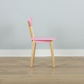 Pink children's chair with natural wooden legs on light hardwood floor against pale gray wall, modern minimalist kids' furniture