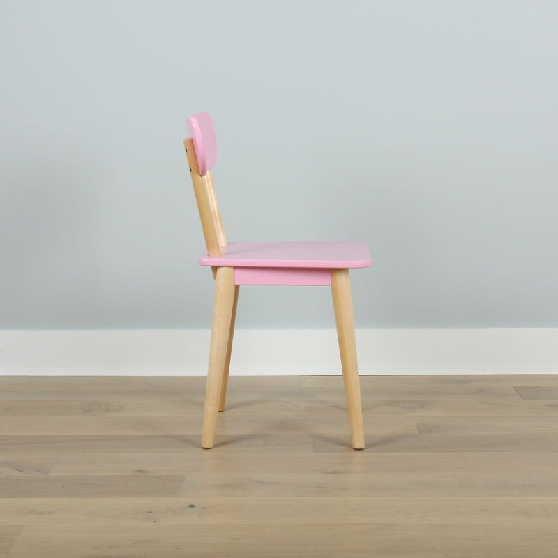 Pink children's chair with natural wooden legs on light hardwood floor against pale gray wall, modern minimalist kids' furniture
