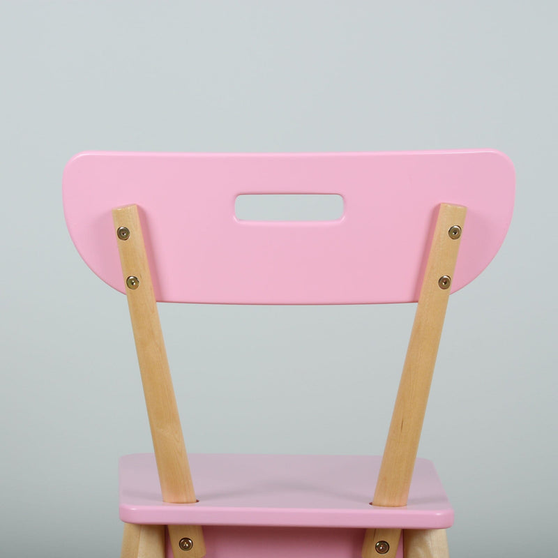 Close-up of a pastel pink wooden chair back with natural wood legs and rectangular handle cutout on a light gray background