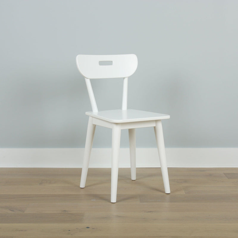 Minimal white wooden chair against a pale gray wall on light hardwood floor — Scandinavian modern interior design