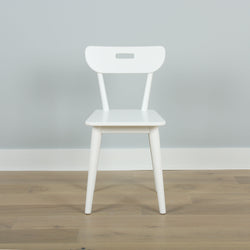 Modern white wooden chair on light wooden floor against gray wall background.