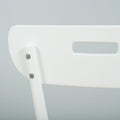 Close-up of white plastic chair back showing screws and rectangular handle cutout, minimalist modern dining chair detail on a soft grey background