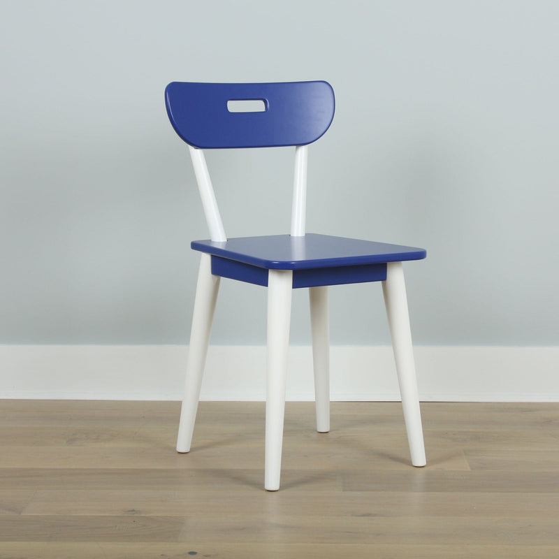 Minimalist blue chair with white legs and cutout backrest on light wood floor against pale gray wall