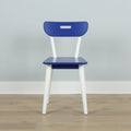 Modern blue dining chair with white angled legs and cutout backrest on light wood floor in minimalist interior
