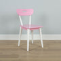 Pastel pink children's chair with white legs on light wood floor against a pale gray wall, modern minimalist kids furniture