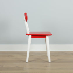 Red and white wooden chair with a modern design on a wooden floor against a light gray wall.