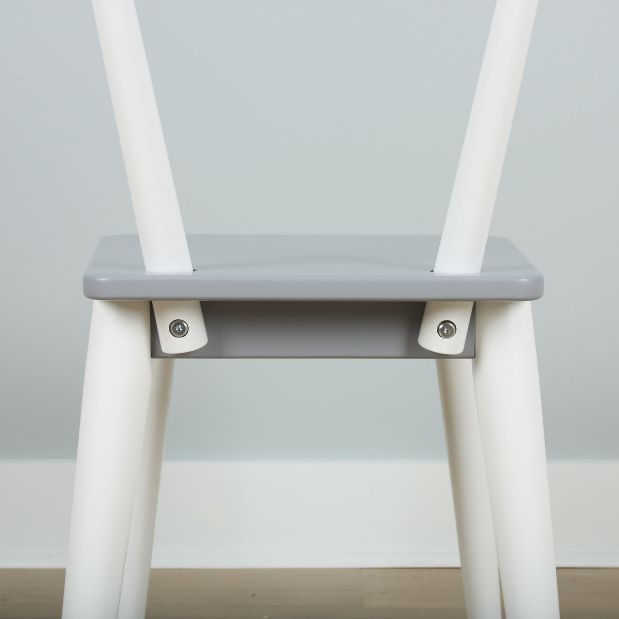 Minimalist gray and white wooden chair with modern design and sleek lines.