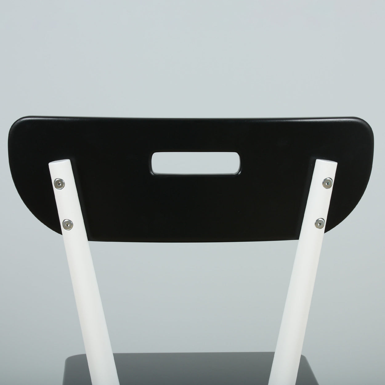 Modern black and white chair with unique backrest design.