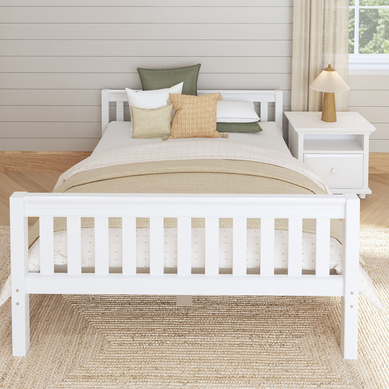 White wooden bed frame with cozy patterned bedding, throw pillows, and a bedside table in a bright and airy modern bedroom.