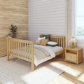 Modern farmhouse bedroom with natural wood bed, shiplap accent wall, textured woven wallpaper, neutral bedding, potted plants and sunlit window