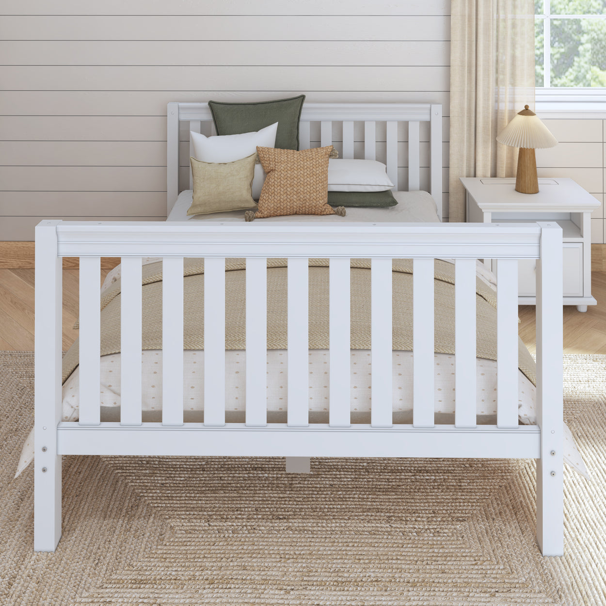 White wooden bed frame with green and beige accent pillows in a cozy bedroom setting.