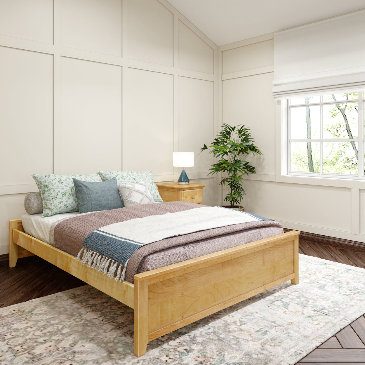 Cozy bedroom with a wooden bed, decorative pillows, bedside table with lamp, and large window with natural light.
