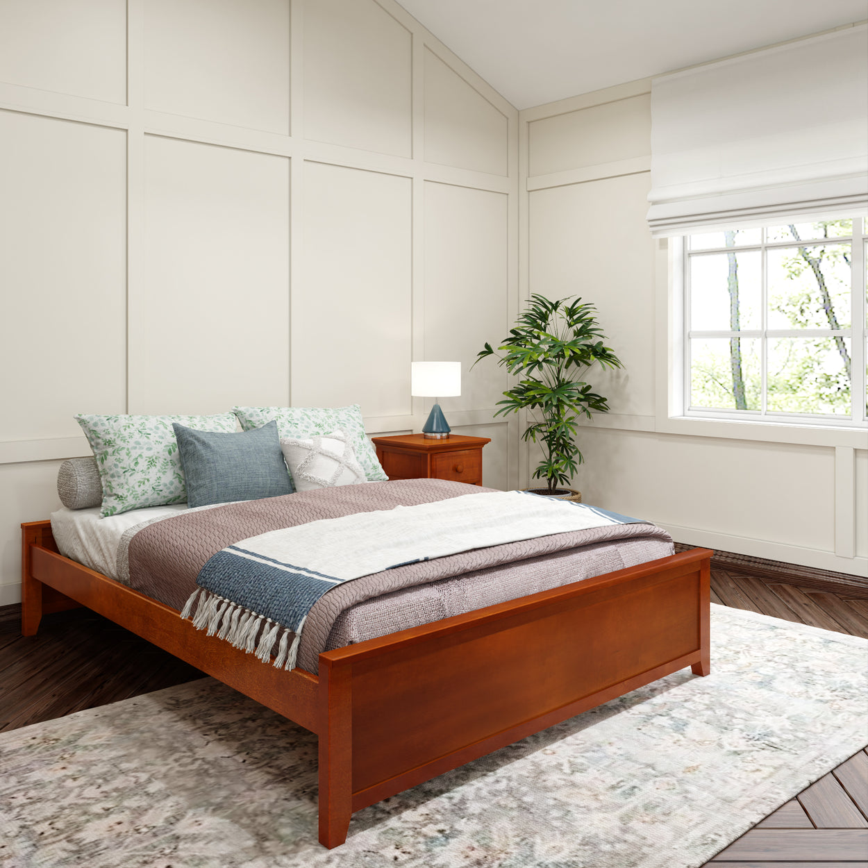 Cozy bedroom with modern wooden bed, layered bedding, floral pillows, elegant nightstand, indoor plant, and large window letting in natural light.