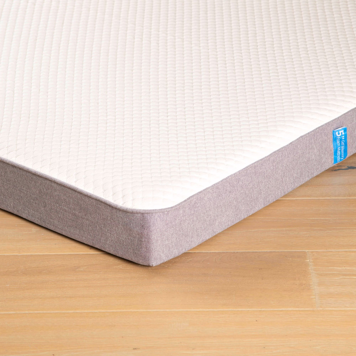 Premium memory foam mattress on wooden floor, showcasing durable design and white quilted surface for optimal comfort.