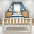 Cozy attic bedroom with sloped ceilings and blue accent wall, white wooden bed with natural wood slats, matching pine nightstands, bedside lamp and minimalist artwork