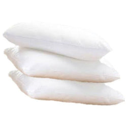 Stack of three soft white pillows on a plain background.