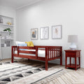 Modern kids bedroom with red wooden toddler bed, white bedding and yellow-blue pillows, wooden nightstand with white lamp, minimalist framed wall art and built-in shelves with plants and decor on a neutral wall