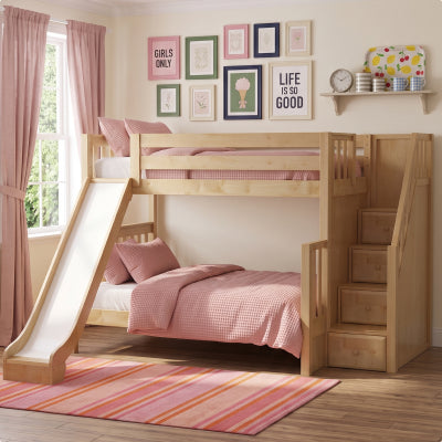 A white wooden toddler bed with a safety guard rail, styled in a child's bedroom with a woman and two young girls sitting on the bed.