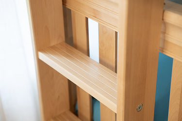 Close-up of light maple wood slatted bed frame headboard with vertical post and visible metal bolt, natural finish bedroom furniture detail