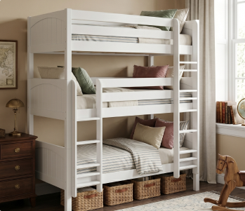 Cozy modern bedroom with white storage platform bed featuring under-bed cubbies, blue quilt and striped pillows, leather-look accent pillow, wooden oar wall decor and light hardwood floor