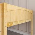 Close-up of light maple wood bed frame headboard with vertical slats and curved top against beige paneled wall in modern bedroom