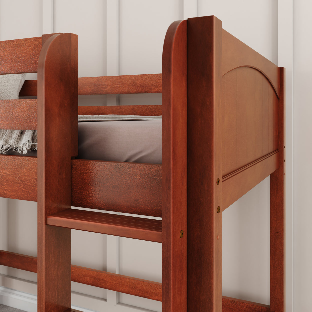 Wooden bunk bed with a warm reddish-brown finish and ladder, positioned against a white paneled wall.