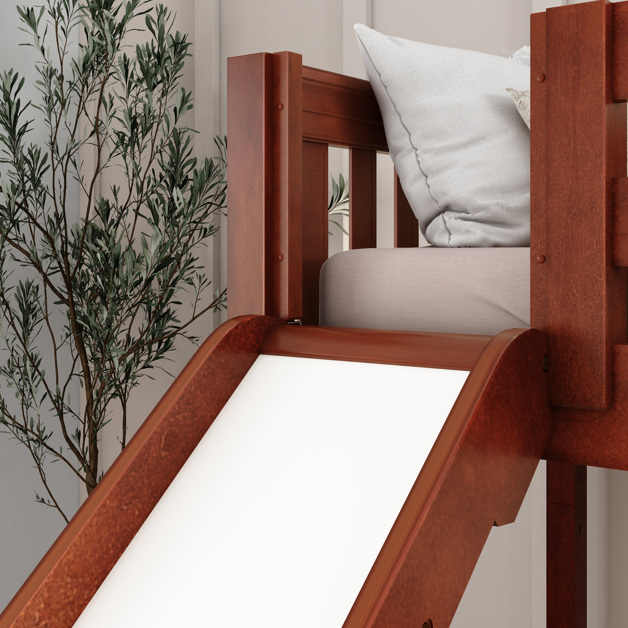 Wooden loft bed with slide and cozy pillow setup in a stylish bedroom.