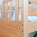 Close-up of light maple bunk bed railing and vertical slats with blue patterned bedding, natural wood bunk bed detail and visible hardware