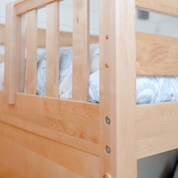 Close-up of light maple wood bunk bed railing and slats with blue patterned bedding, modern solid wood kids bunk bed detail