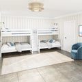 Bright coastal farmhouse kids' bedroom with white bunk beds, beige shiplap walls, neutral area rug, tiled floor and blue accents