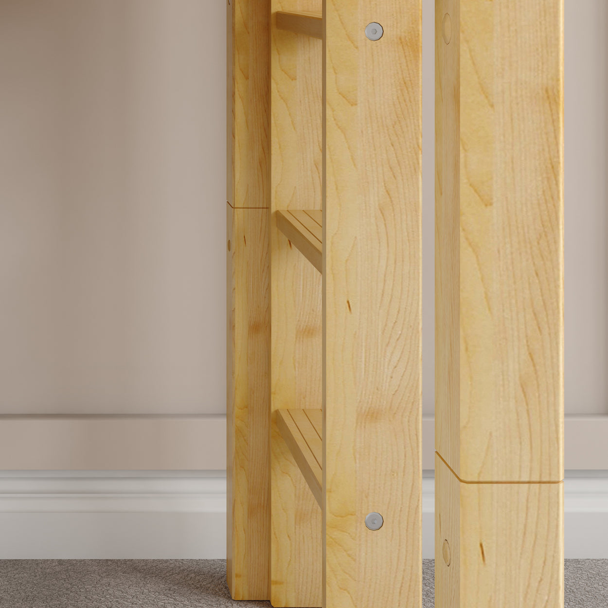 Wooden table leg corner detail against beige wall and carpeted floor.